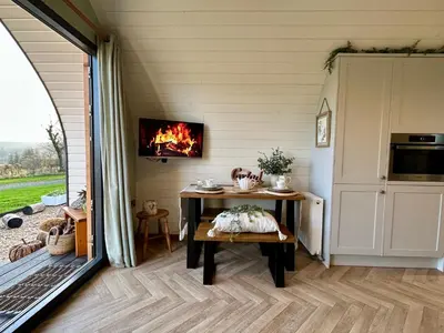 a living room with a table and a fireplace at Willow in Llanidloes