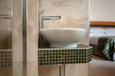 a bathroom with a sink on a tiled counter at Gwesty Cymru in Aberystwyth