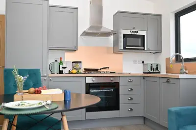 a kitchen with a table and a counter top at Cae Dafadd in Newtown