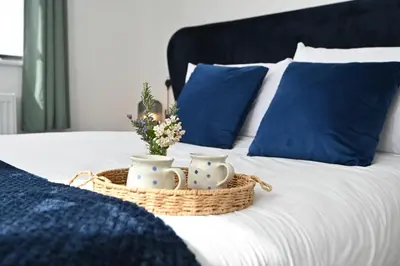 a bed with a basket of flowers and blue pillows at Cae Dafadd in Newtown