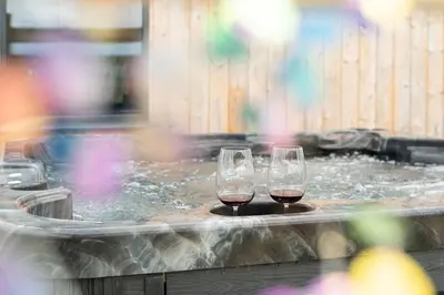 two glasses of wine sitting in a hot tub at Cae Pren in Newtown