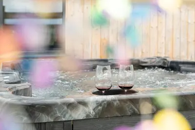 two glasses of wine sitting in a hot tub at Cae Bedw in Newtown