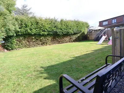 a park with a bench and a playground with a slide at Llangollen in Llangollen