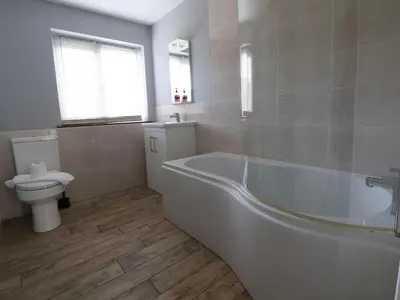 a white bathroom with a tub and a toilet at Llangollen in Llangollen