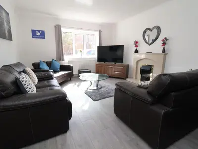 a living room with two leather couches and a fireplace at Llangollen in Llangollen