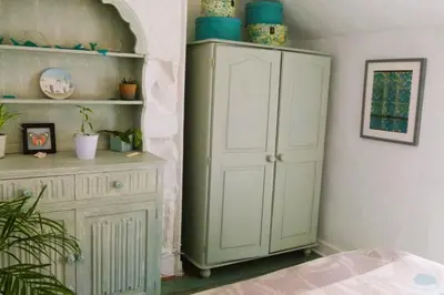 a bedroom with a white cabinet and a shelf at 2-Bedroom cottage in Barmouth old town with sea views in Barmouth