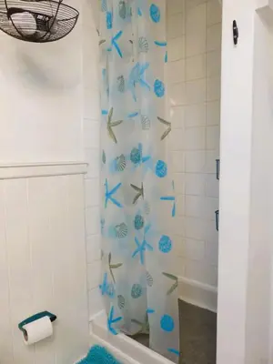 a bathroom with a shower curtain with blue butterflies at 2-Bedroom cottage in Barmouth old town with sea views in Barmouth