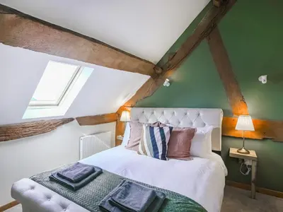 a bedroom with a white bed and a green wall at Uk46589 - Kibble in Church Stretton