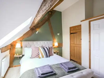 a bedroom with a white bed and green walls at Uk46589 - Kibble in Church Stretton
