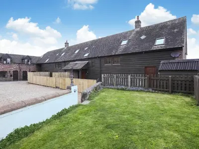 a house with a wooden fence and a yard at Uk46589 - Kibble in Church Stretton