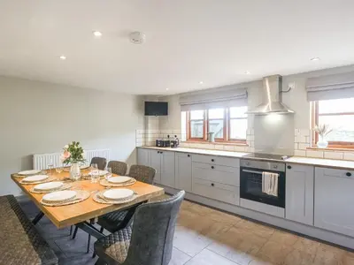 a kitchen with a wooden table and chairs in a room at Uk46589 - Kibble in Church Stretton