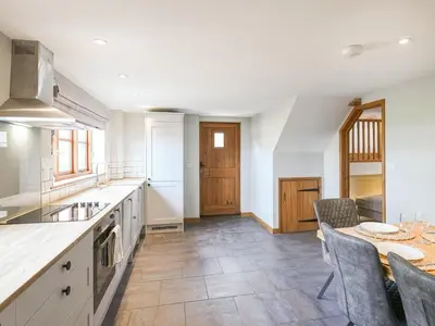 a kitchen with a table and chairs and a counter top at Uk46589 - Kibble in Church Stretton