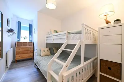 a bedroom with two bunk beds and a ladder at Relaxing Aberdovey Retreat, close to beach in Aberdyfi