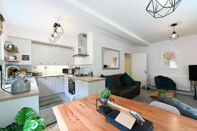 a kitchen and a living room with a wooden table at Relaxing Aberdovey Retreat, close to beach in Aberdyfi
