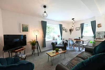 a living room with a couch and a tv at Relaxing Aberdovey Retreat, close to beach in Aberdyfi