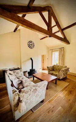a living room with a couch and a table at Apartment at Llanerchydol Hall in Welshpool