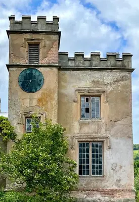 a building with a clock on the side of it at Apartment at Llanerchydol Hall in Welshpool