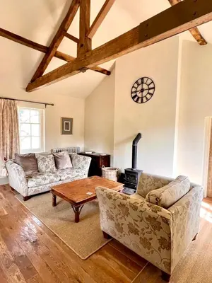 a living room with two couches and a table at Apartment at Llanerchydol Hall in Welshpool