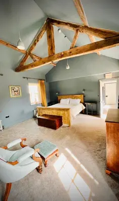 a large bedroom with a bed and a chair at Apartment at Llanerchydol Hall in Welshpool