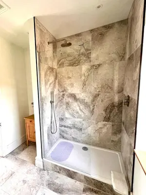 a bathroom with a shower with a glass door at Apartment at Llanerchydol Hall in Welshpool