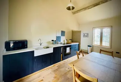 a kitchen with a sink and a table with a microwave at Apartment at Llanerchydol Hall in Welshpool