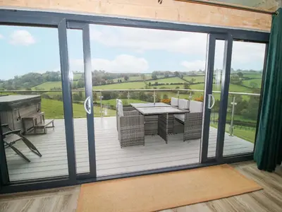 a view from a deck with a table and chairs at Bwncath in Welshpool