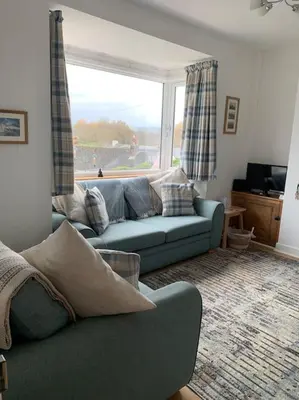 a living room with a couch and a large window at Mountain views in the heart of Brecon Town in Brecon