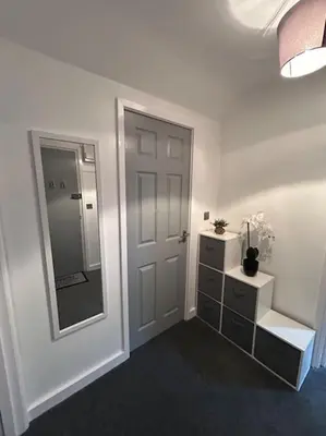 a white room with a door and a mirror at Rock Park Penthouse in Llandrindod Wells
