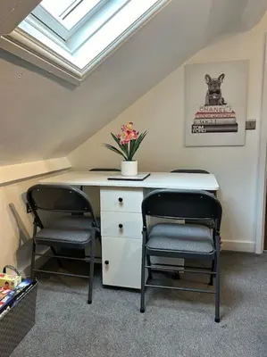 a room with two chairs and a desk with a window at Rock Park Penthouse in Llandrindod Wells