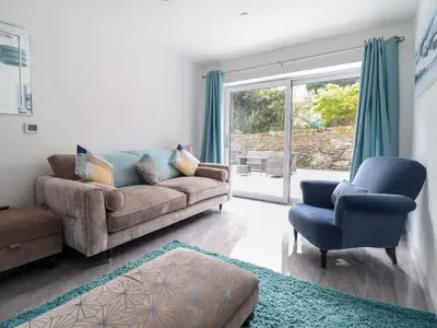 a living room with a couch and two chairs at Ty Mawr in Penrhyndeudreath