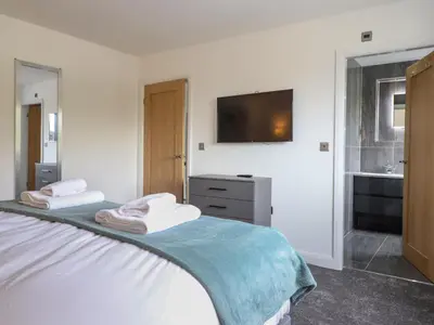a bedroom with a bed with a tv on the wall at Ty Mawr in Penrhyndeudreath
