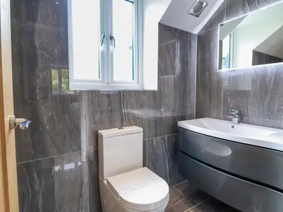 a bathroom with a toilet and a sink and a mirror at Ty Mawr in Penrhyndeudreath