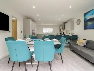 a dining room with a table and blue chairs at Ty Mawr in Penrhyndeudreath
