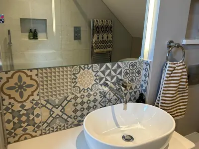 a white sink in a bathroom with tiles on the wall at Hafan in Glasbury