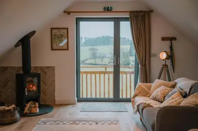 a living room with a couch and a fireplace at Hafan in Glasbury