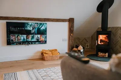a living room with a fireplace and a movie poster at Hafan in Glasbury