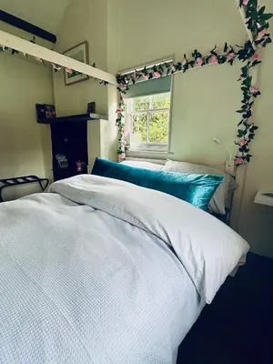 a bedroom with a bed with white sheets and a window at Tiny Romantic Retreat with Hot Tub on a Country Estate near Cardigan Bay in Eryri Snowdonia in Llanbedr