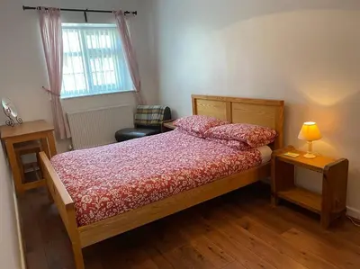 a bedroom with a bed and a lamp and a chair at Cottage in the Countryside Near New Quay West Wales in Llandysul