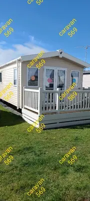 a mobile home with yellow writing on the grass at Sean's 569 cader court 045 in Talybont