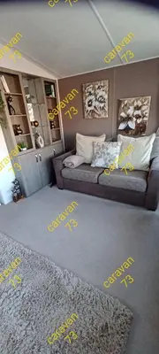 a living room with yellow writing on the floor at Caravan 73 snowdon summit 013 in Talybont
