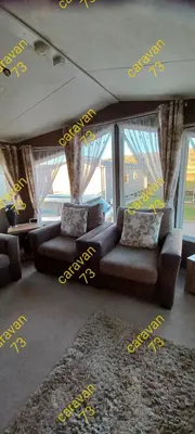 a living room with yellow writing on the wall at Caravan 73 snowdon summit 013 in Talybont
