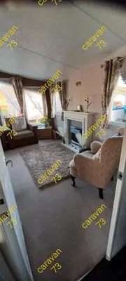 a living room with yellow writing on the wall at Caravan 73 snowdon summit 013 in Talybont