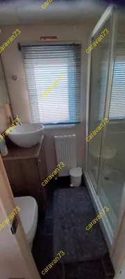 a bathroom with a toilet and a sink and a shower at Caravan 73 snowdon summit 013 in Talybont