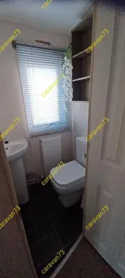 a small bathroom with a toilet and a window at Caravan 73 snowdon summit 013 in Talybont