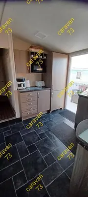 a kitchen with yellow writing on the floor at Caravan 73 snowdon summit 013 in Talybont