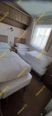 a room with three beds and a window in it at Caravan 73 snowdon summit 013 in Talybont