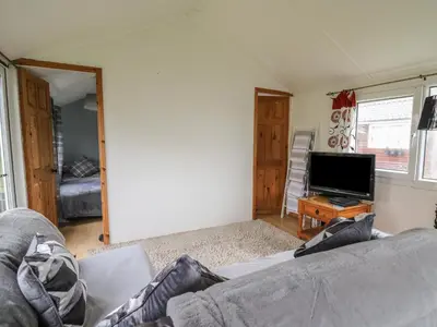 a living room with a couch and a flat screen tv at Chalet 32 in Aberystwyth