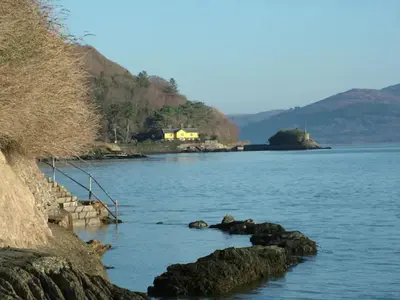 a large body of water with a house in the distance at Stunning views of Ynyshir & Southern Snowdonia in Machynlleth