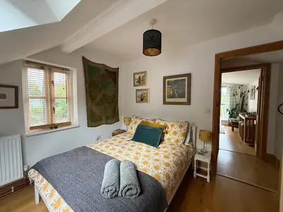 a bedroom with a bed with a blue pillow at Stunning views of Ynyshir & Southern Snowdonia in Machynlleth