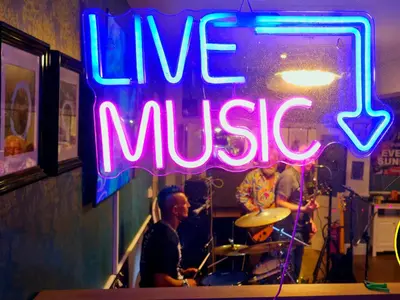 a neon sign that says live music in a room at The Springfield Hotel in Fairbourne
